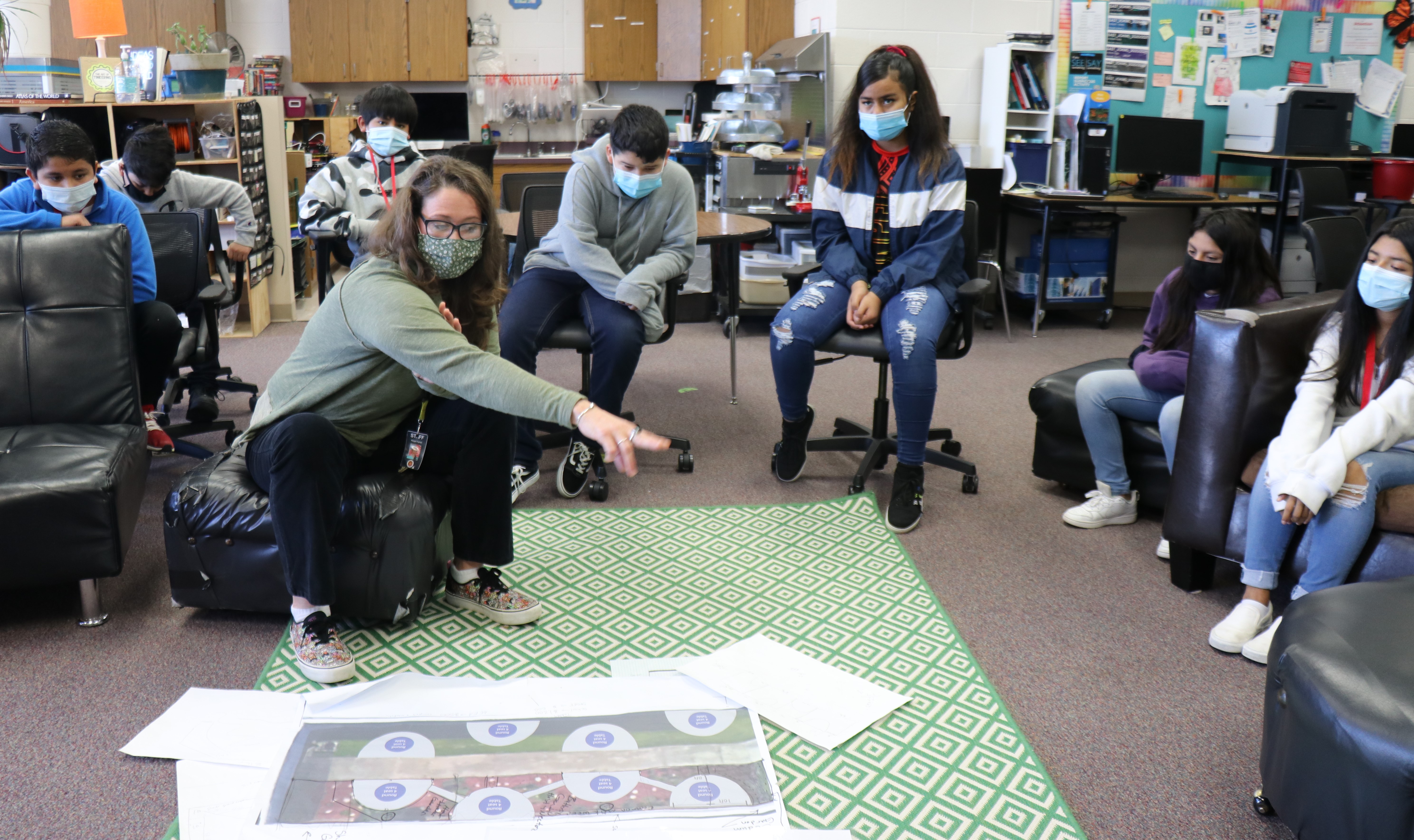 Teacher and students describing plans for an outdoor learning space.