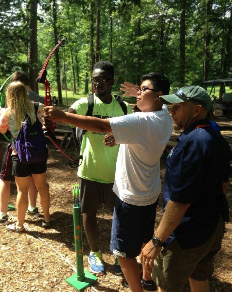 Instructor with archery students using a wrist strap release aid.