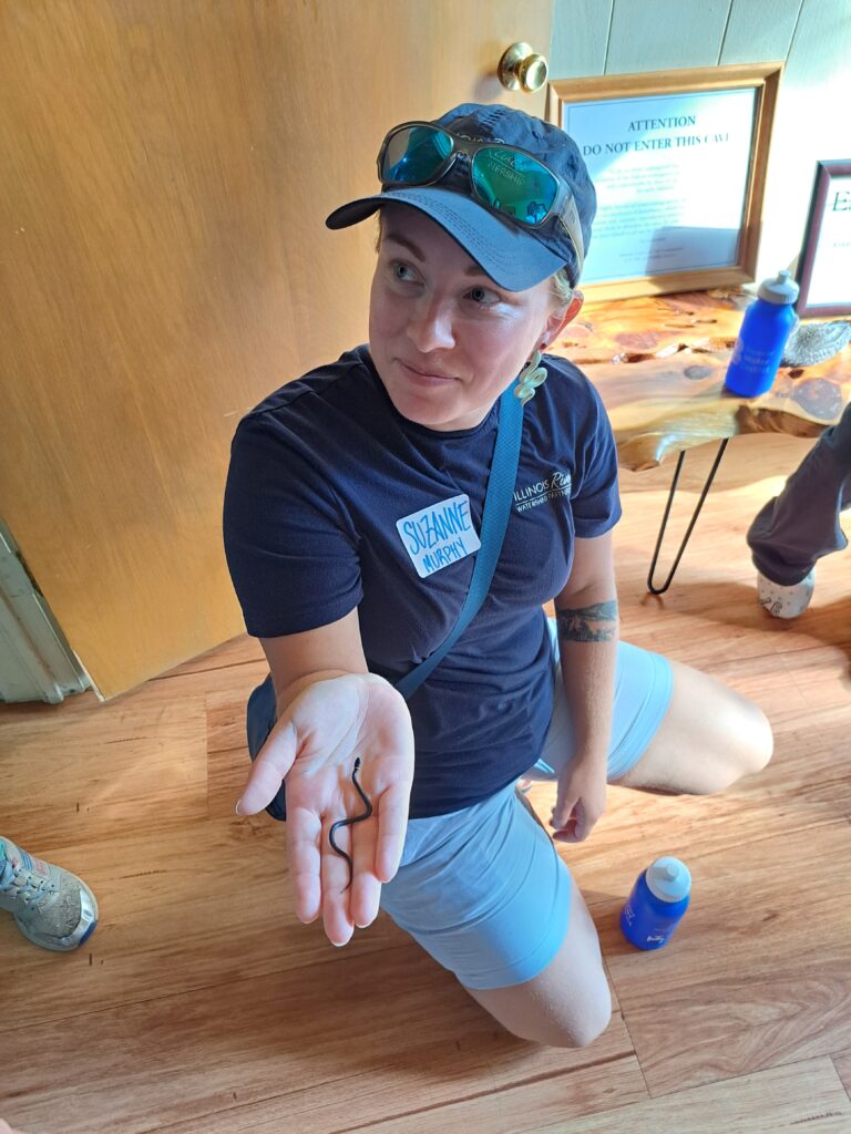 Woman holding a small ring neck snake.