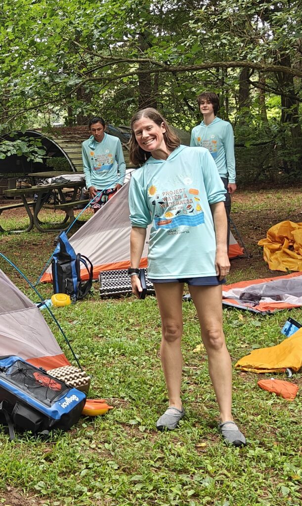 Woman outside setting up a camping site.