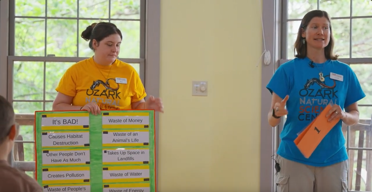 one woman holding a sign and another woman talking