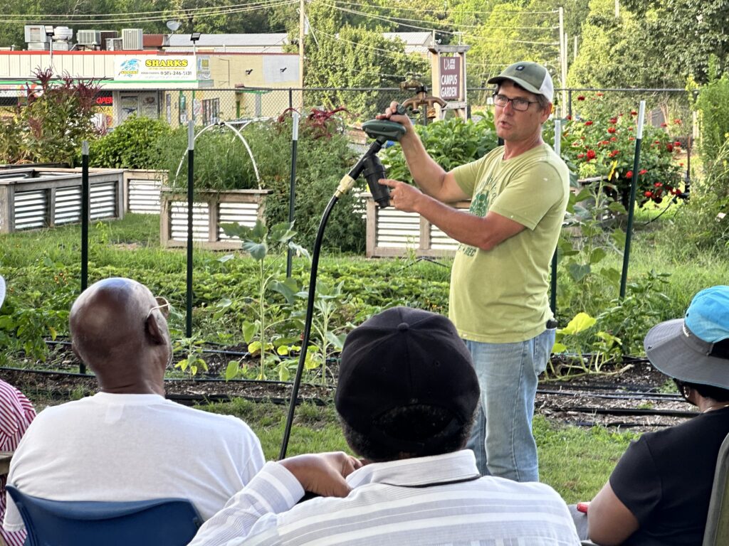man demonstrating gardening irrigation tool